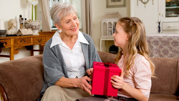 Бабушка дарит подарок внучке