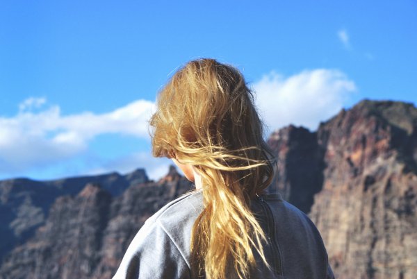 Девушка в горах со спины блондинка