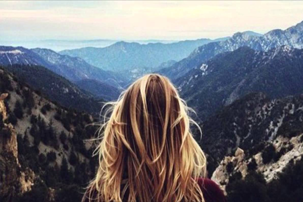 Блондинка в горах со спины
