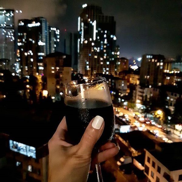 Бокал вина на фоне ночного города
