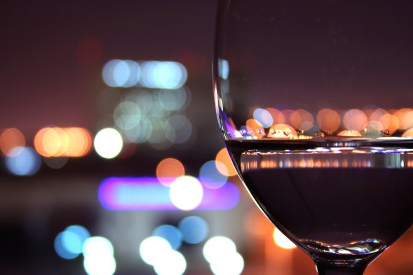 Бокал вина на фоне ночного города