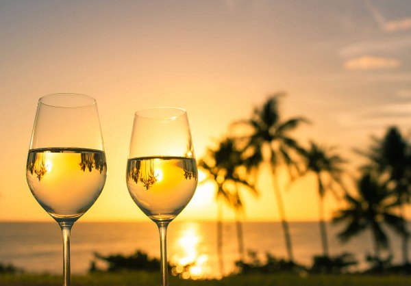 Бокал вина на фоне моря и заката