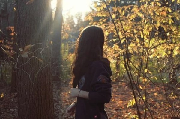 Девушка с длинными волосами со спины осенью