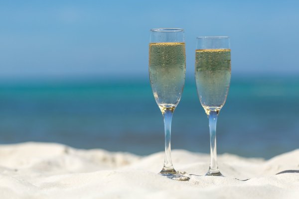Два бокала шампанского на берегу моря