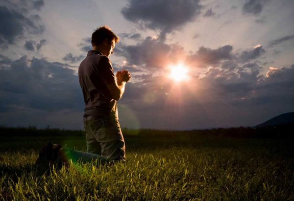 Человек молится в поле