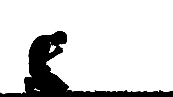 Человек молится на коленях
