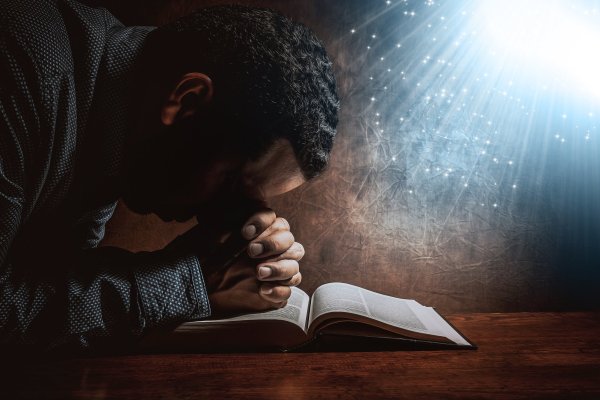 Человек молится с Библией