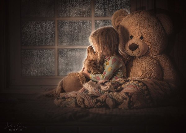 Девушка обнимает плюшевого медведя