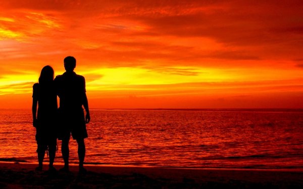 Девушка и парень на фоне моря и заката