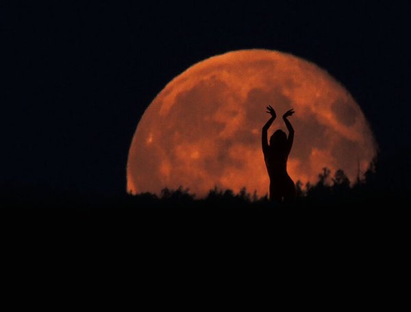 Женский силуэт на фоне Луны