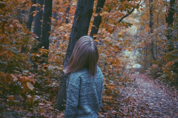Девушка в лесу осенью со спины