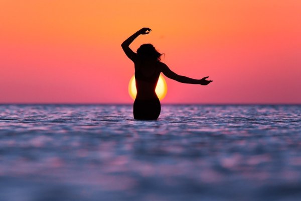 Девушка на фоне заката на море