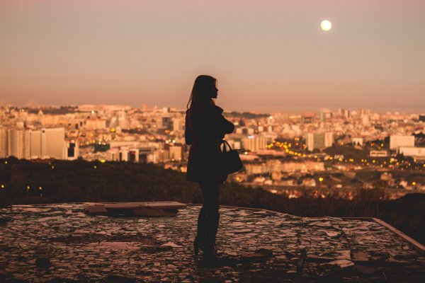 Девушка на фоне заката со спины в городе