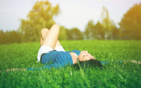 Женщина сидит на траве