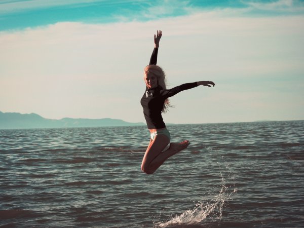 Девушка прыгает в море