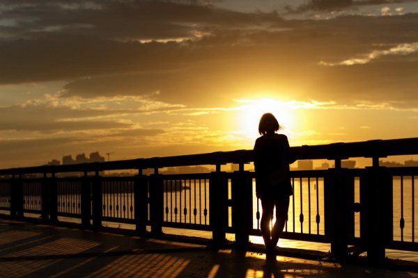 Девушка в закате на мосту