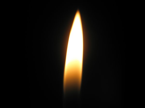 Огонек свечи на черном фоне
