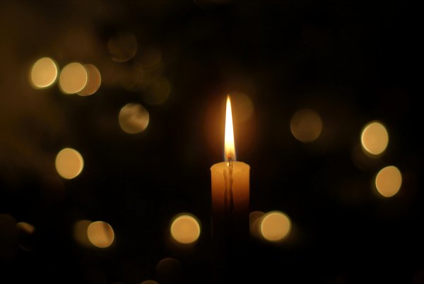 Огонек свечи на темном фоне
