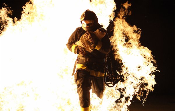 Пожарный выносит ребенка из огня