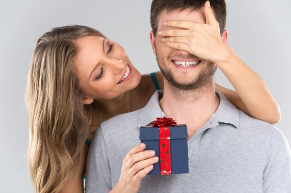 Девушка дарит подарок мужчине