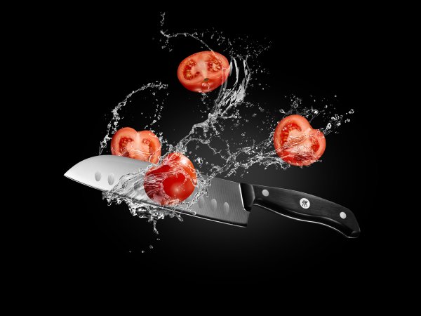 Нож разрезает помидор