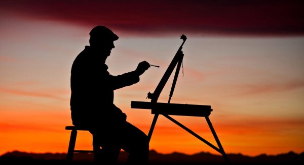 Художник на фоне заката