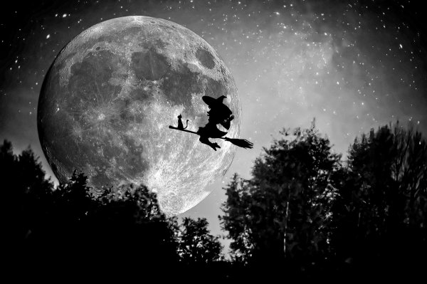 Ведьма на метле на фоне Луны