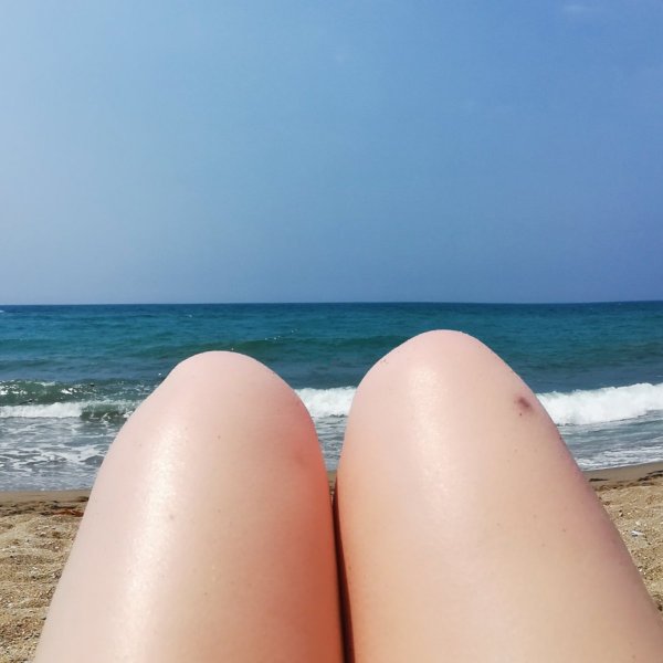 Ноги на песке на фоне моря