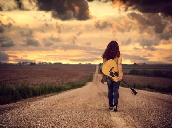 Девушка с гитарой на дороге