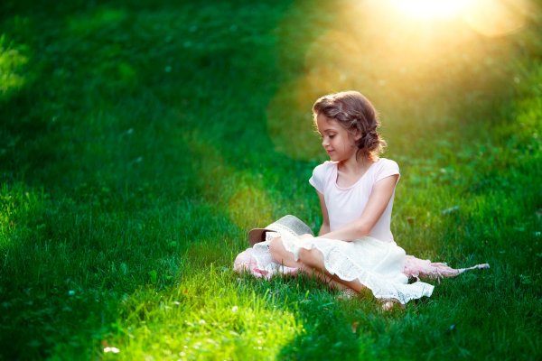 Девочка сидит на траве