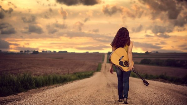 Девушка с гитарой на дороге