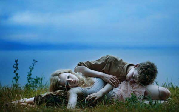 Мужчина и женщина лежат на траве