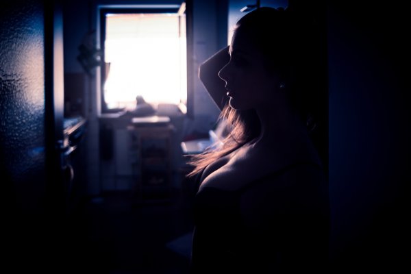 Девушка в темноте у окна