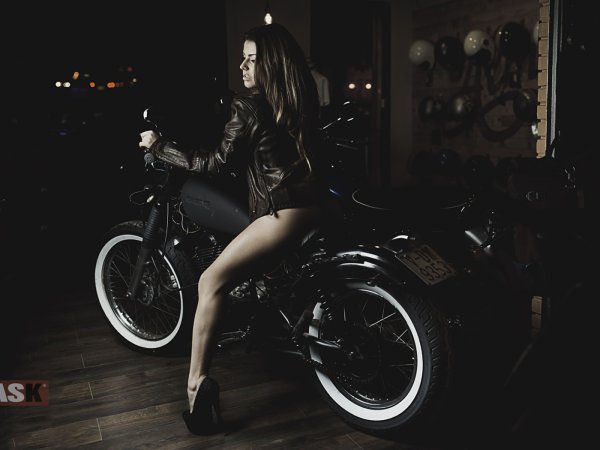Девушка на мотоцикле на черном фоне