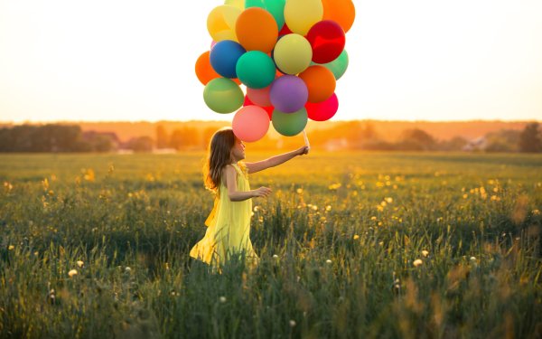 Девочка с шариками в поле