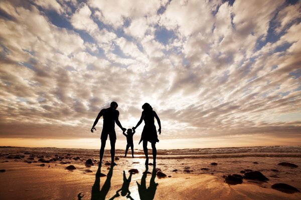 Семья на берегу моря на закате