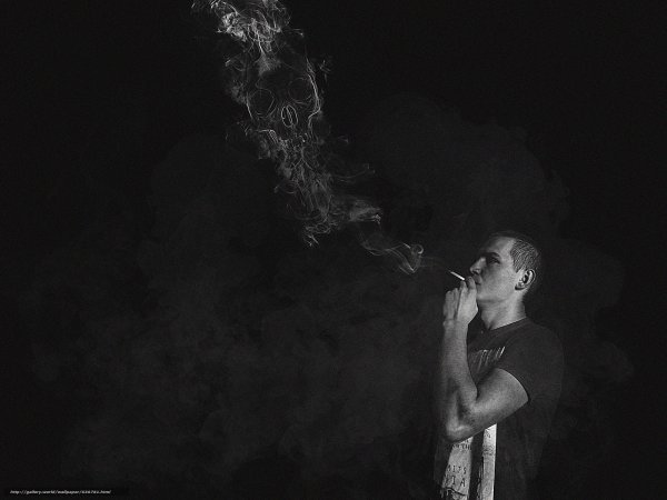 Мужчина с сигаретой в темноте