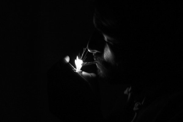 Парень с сигаретой в темноте