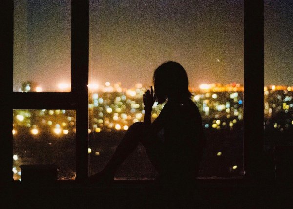 Девушка у окна ночного города