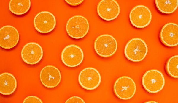 Апельсин на оранжевом фоне