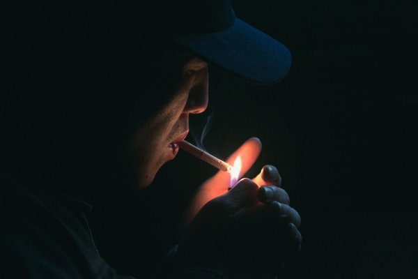 Парень курит в темноте