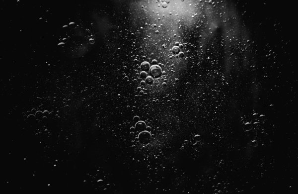 Пузыри под водой на черном фоне