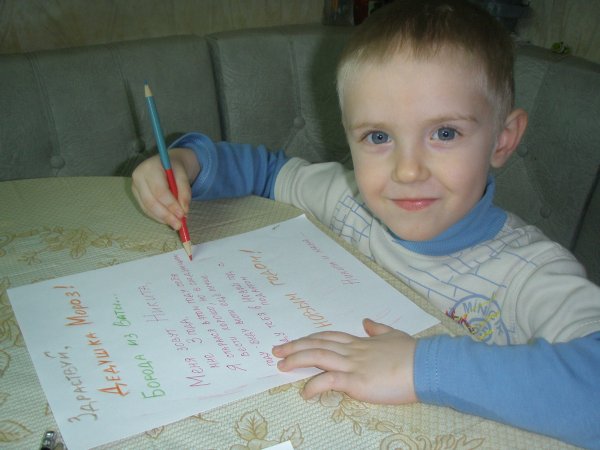 Мальчик пишет письмо деду Морозу