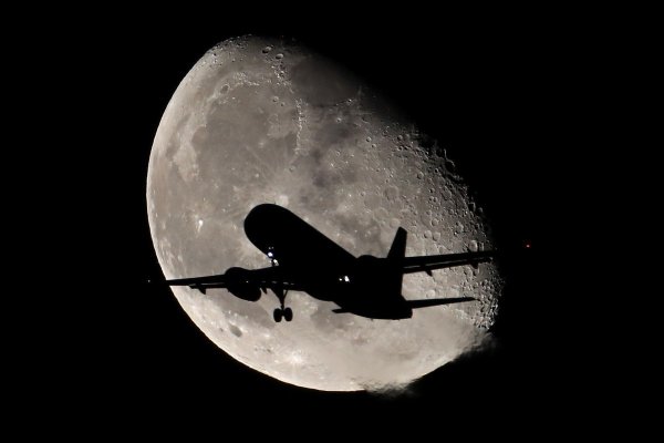 Силуэт самолета на фоне Луны