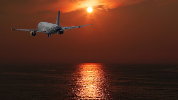 Самолет над морем на закате