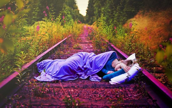 Девушка лежит на железной дороге