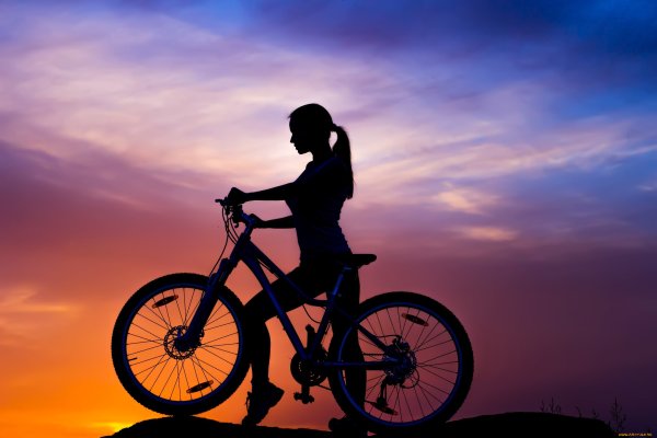 Девушка на велосипеде на закате