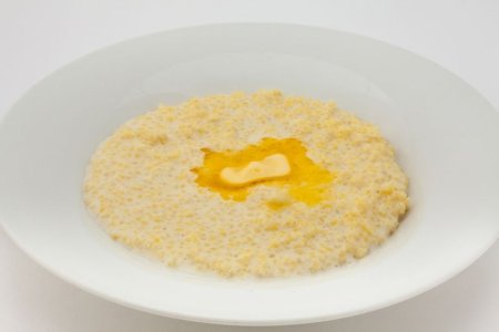 Каша пшенная на молоке на белом фоне