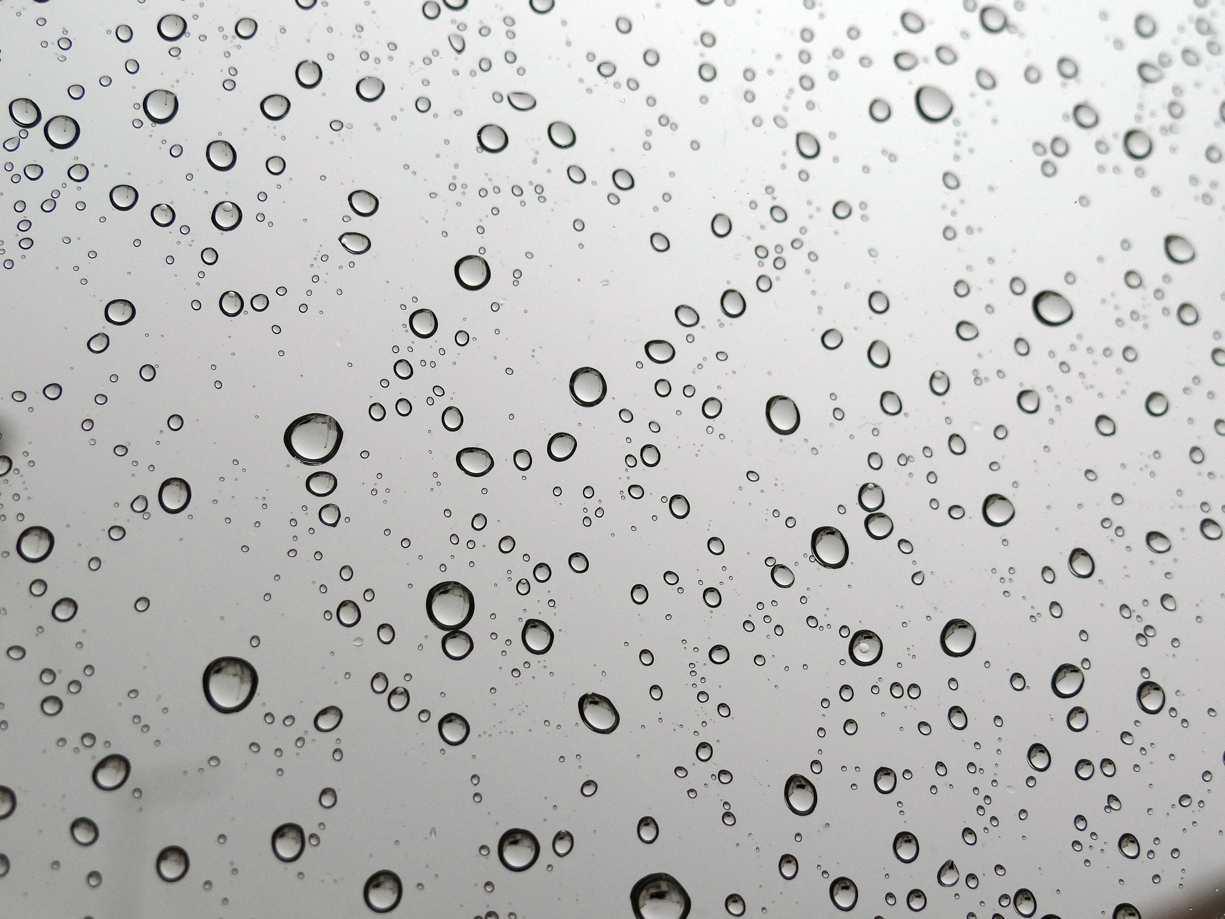 Сверху капает вода. Фон капли. Капли воды. Капли на стекле. Капли дождя.