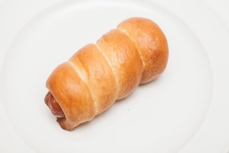 Сосиска в тесте на белом фоне